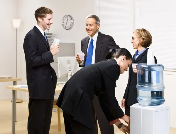 Business drinking water at water cooler — Stock Photo, Image