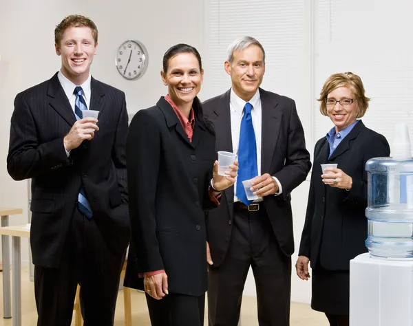 Business drinking water at water cooler — Stock Photo, Image