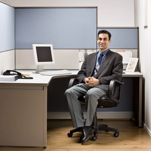 Empresário sentado na mesa no cubículo — Fotografia de Stock