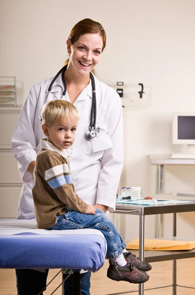 Doctor giving boy checkup in doctor office Stock Picture