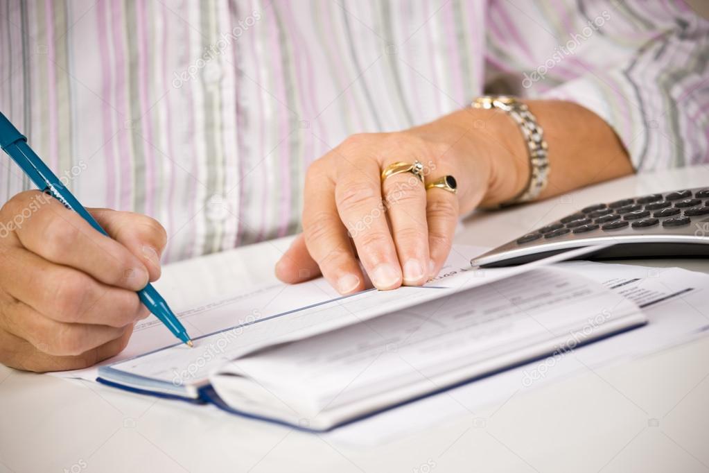 Senior woman writing checks