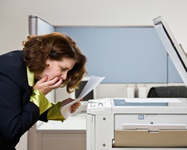 Businesswoman having trouble with copy machine clipart