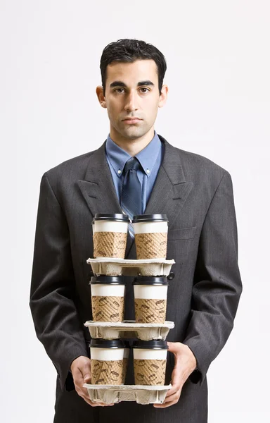 Empresário transportando pilha de xícaras de café — Fotografia de Stock