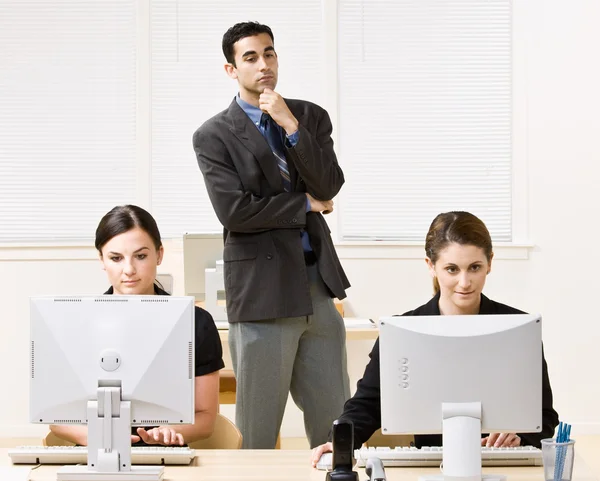 Businessman watching co-workers work — Stock Photo, Image