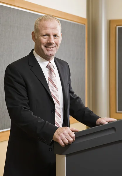 Business Man Standing at Podium Smiling — Stock Photo, Image