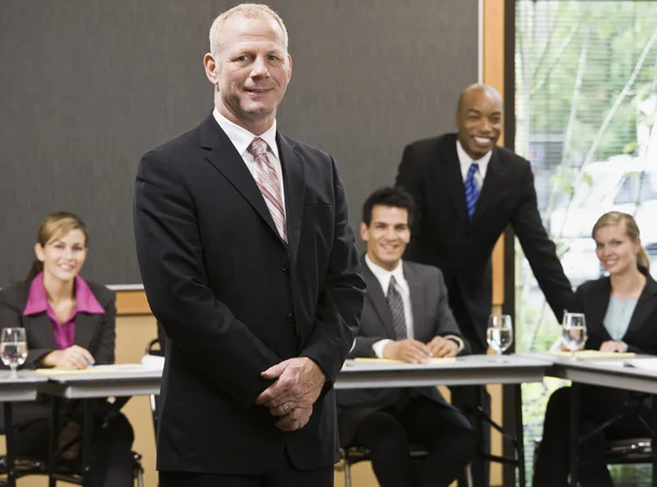 Empresario de pie y sonriendo — Foto de Stock