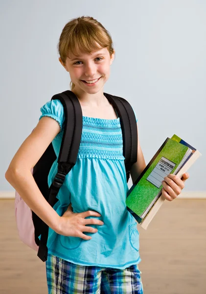 Jong meisje met rugzak en school boeken — Stockfoto
