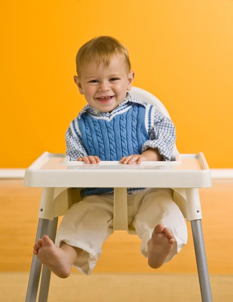 Młody chłopak w krzesełko — Zdjęcie stockowe