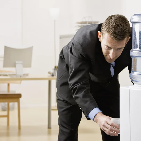 Zakenman aan het water cooler — Stockfoto