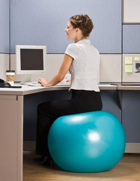 Mujer de negocios sentada en la pelota de ejercicio en el escritorio — Foto de Stock