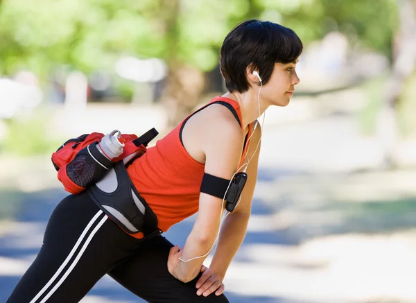 Vrouw dragen mp3-speler en stretching — Stockfoto