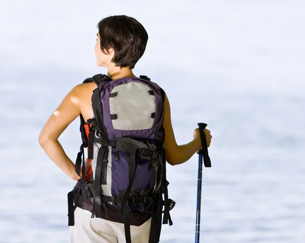 Woman hiking with backpack and walking stick — Stock Photo, Image