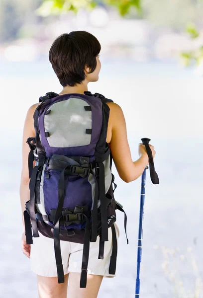 Woman hiking with backpack and walking stick — Stock Photo, Image