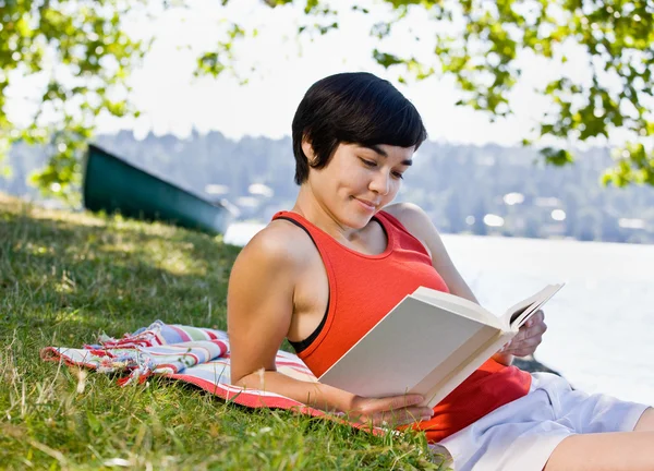 Park yerinde kitap okuyan bir kadın. — Stok fotoğraf