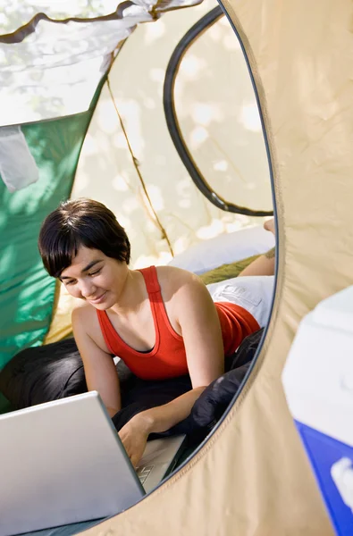 Woman using laptop in tent — Stock Photo, Image