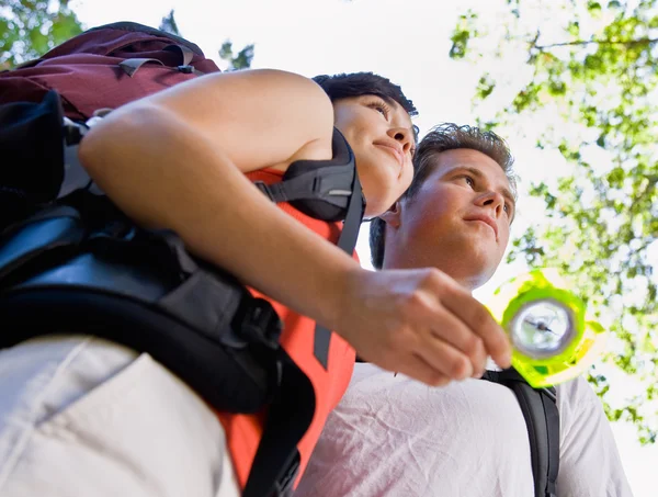 Couple with backpacks looking at compass — Stock Photo, Image