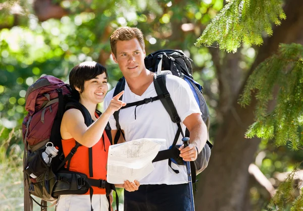 Casal com mochilas olhando para o mapa — Fotografia de Stock