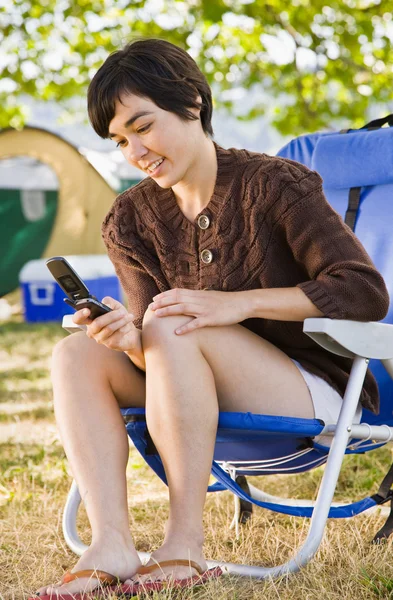 Camper text messaging on cell phone — Stock Photo, Image