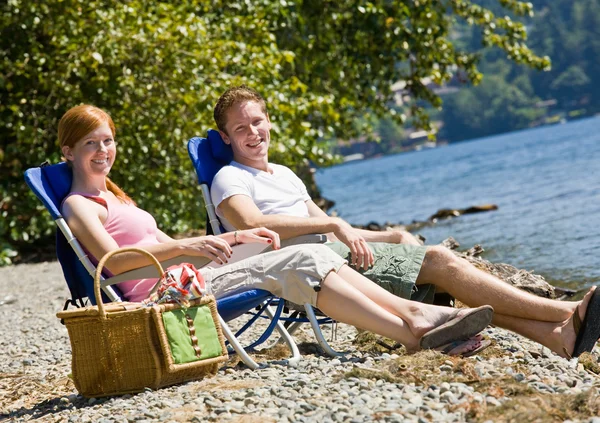 Paar met picknick in de buurt van stream — Stockfoto