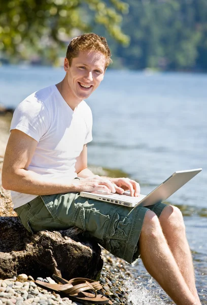 Mann benutzte Laptop in Bachnähe — Stockfoto