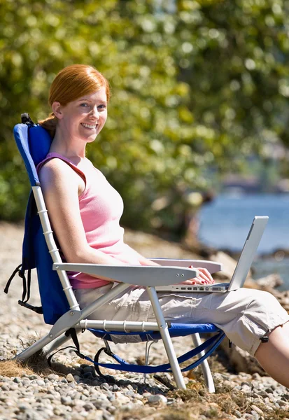 Frau benutzte Laptop in Bachnähe — Stockfoto