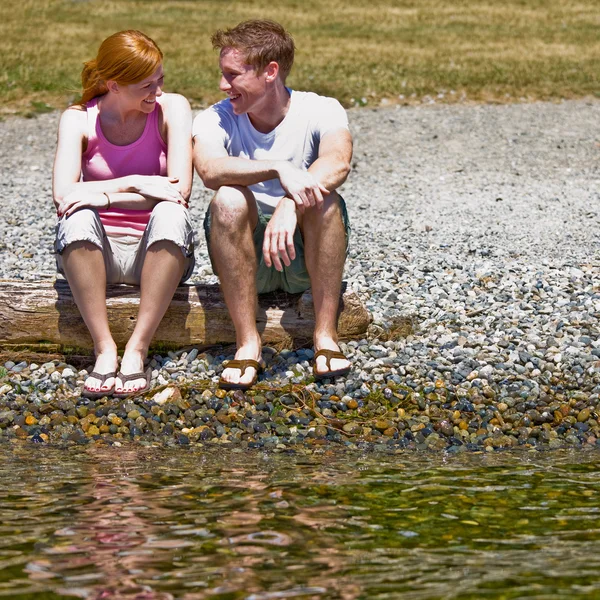 Paar sitzt am Bach — Stockfoto