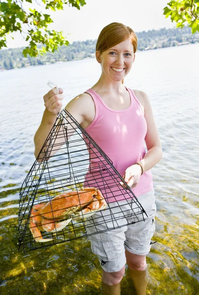 Woman holding crab in trap — Stock Photo, Image