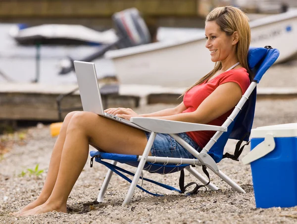 Mujer usando laptop en la playa — Stok fotoğraf