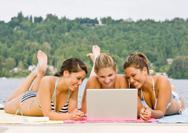 Przyjaciele na molo za pomocą laptopa — Zdjęcie stockowe