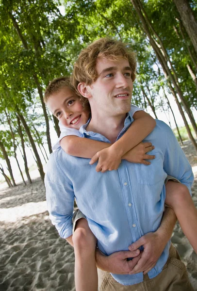 Father giving son piggy back ride — Stock Photo, Image