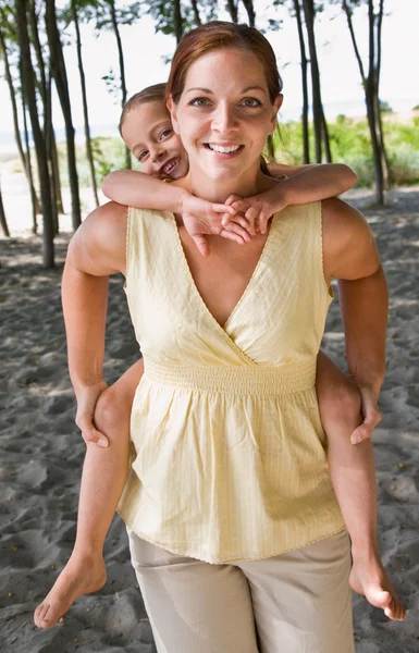 Mother giving daughter piggy back ride — Stock Photo, Image