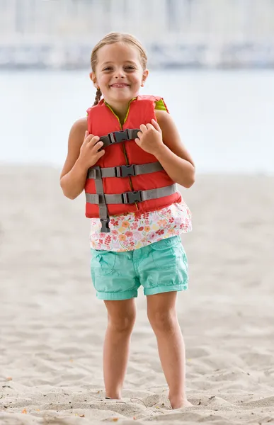 Girl wearing life jacket at beach — Stock Photo, Image