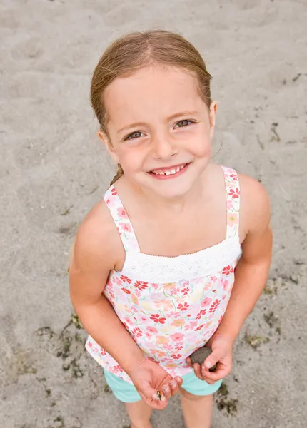 Ragazza che tiene rocce in spiaggia — Foto Stock