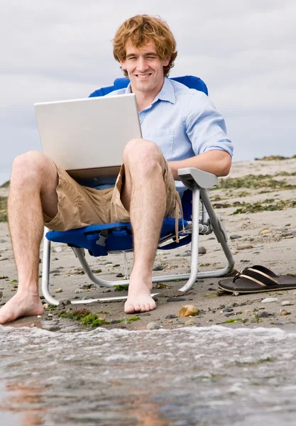 Man använder laptop på stranden — Stockfoto