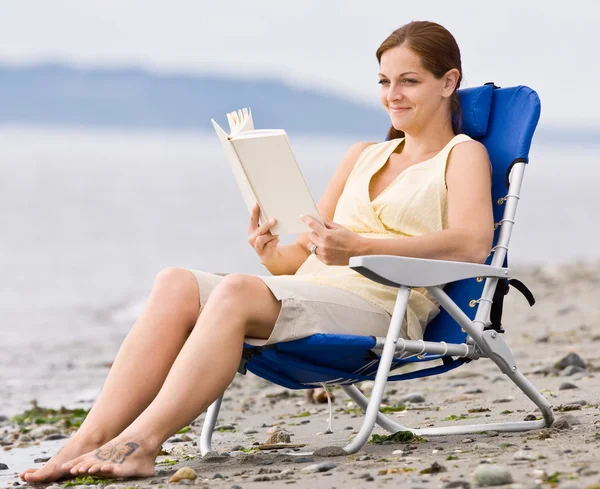 Vrouw lezing boek bij strand — Stockfoto