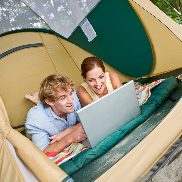 Paar leggen in tent met behulp van laptop — Stockfoto