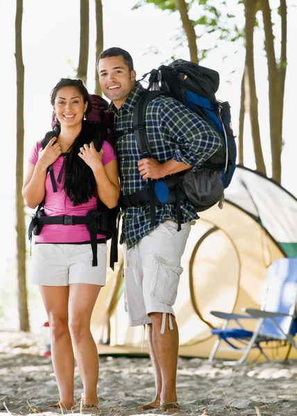 Casal carregando mochilas no acampamento — Fotografia de Stock