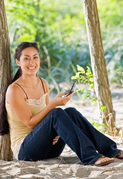 Vrouw voor SMS-berichten op mobiele telefoon op strand — Stockfoto