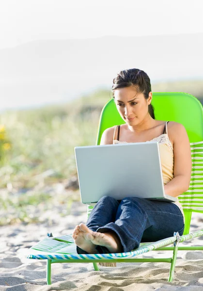 Kobieta korzysta z laptopa na plaży — Zdjęcie stockowe