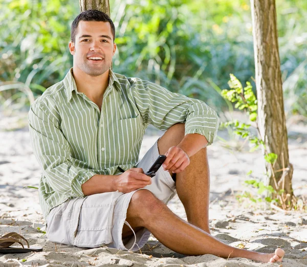 Man text messaging on cell phone at beach — Stock Photo, Image