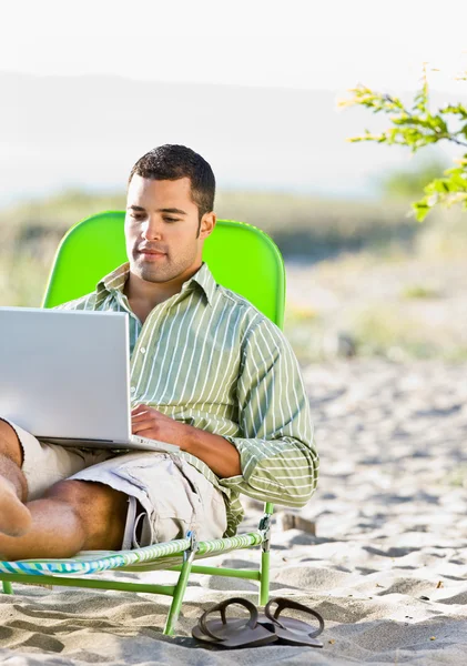 Man met laptop op strand — Stockfoto