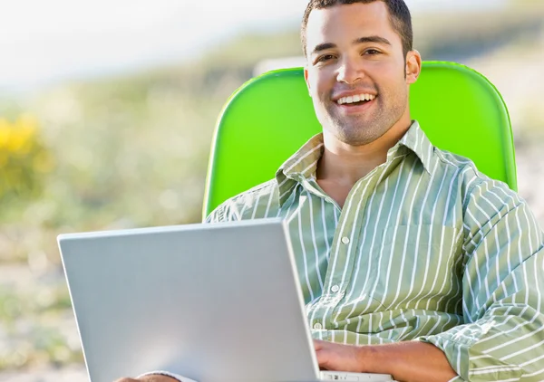 Homem usando laptop na praia — Fotografia de Stock