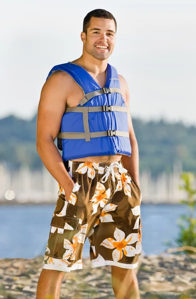 Homme portant un gilet de sauvetage à la plage — Photo