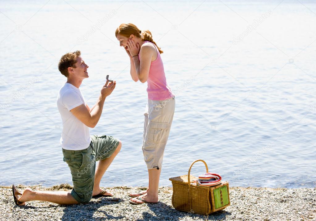 Boyfriend proposing to girlfriend near stream