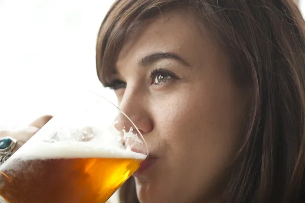 Junge Frau trinkt Bier Stockbild