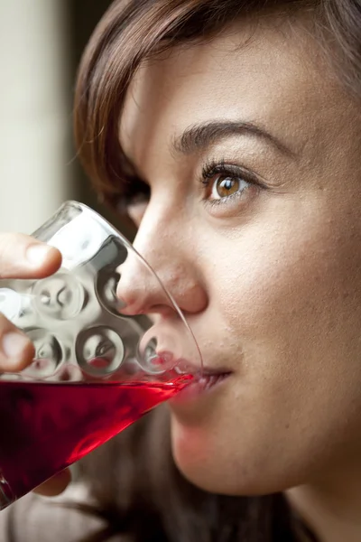 Junge Frau trinkt Preiselbeersaft Stockfoto