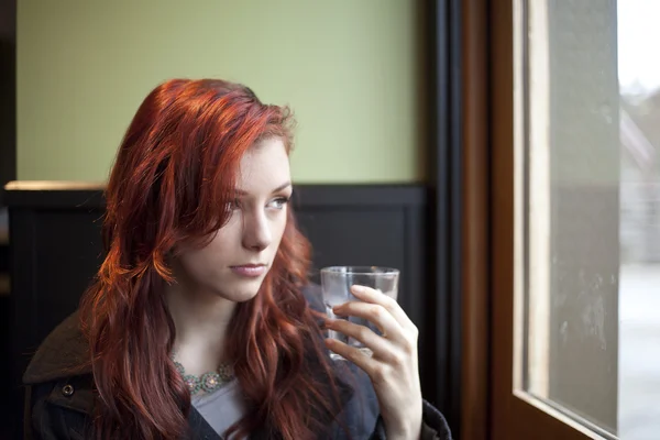 Mladá žena s krásnými kaštanovými vlasy pitnou vodou — Stock fotografie