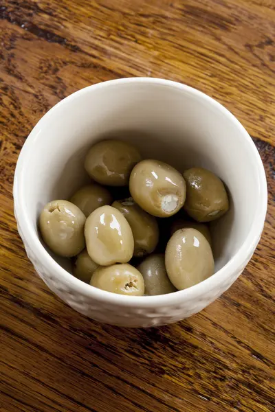 Gröna oliver i en vit skål — Stockfoto