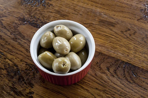 Aceitunas verdes en un tazón rojo y blanco —  Fotos de Stock