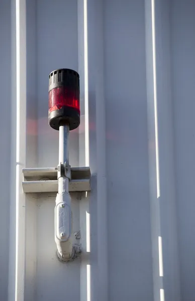 Parede de metal branco com luz vermelha montada — Fotografia de Stock